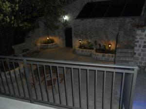 a patio with a fence and some lights at Apartments David in Perast