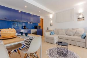 una cucina e un soggiorno con armadi blu di Sa Perdiu 30 a Cala Santandria
