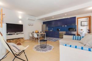 a living room with a white couch and a kitchen at Sa Perdiu 30 in Cala Santandria