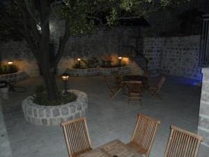 a patio with chairs and a tree at night at Apartments David in Perast