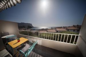 een balkon met een tafel en stoelen en uitzicht bij HORIZON BLEU Vue Mer in Cassis