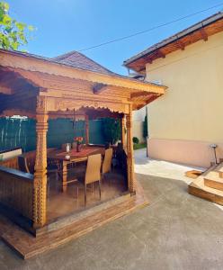 an outdoor pavilion with a table and chairs at Pensiunea Casa Cristal in Târgu Jiu