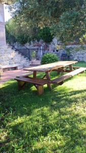 una mesa de picnic de madera en el césped en Villa La Encina, en Quijas