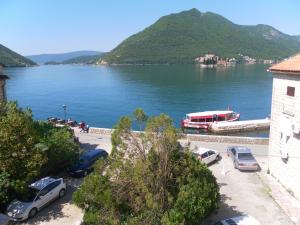 a view of a large body of water with cars parked at Apartments David in Perast