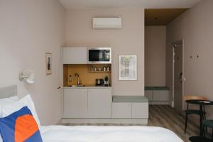 a bedroom with a bed and a small kitchen at Hotel Bries Den Haag - Scheveningen in The Hague