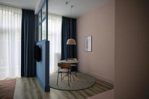 a room with a table and a chair and a window at Hotel Bries Den Haag - Scheveningen in The Hague