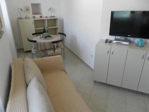 a living room with a couch and a tv and a table at Apartments David in Perast