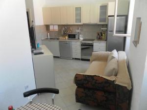 a kitchen with a couch and a kitchen with appliances at Apartments David in Perast