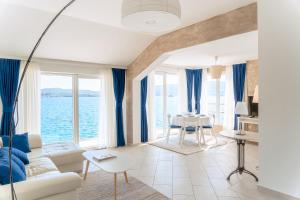 ein Wohnzimmer mit blauen Vorhängen und Blick auf das Wasser in der Unterkunft Seafront apartments in Tivat