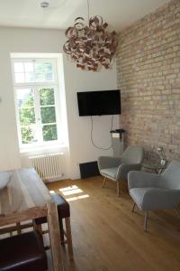 a living room with a tv and a brick wall at Apartment 1 in Mannheim