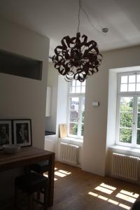 uma sala de jantar com um lustre e duas janelas em Apartment 1 em Mannheim