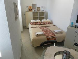a small room with a bed and a table at Apartments David in Perast