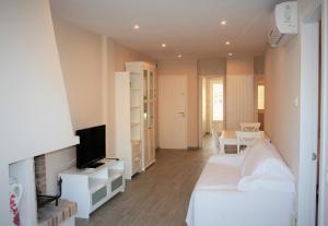 una camera con letto bianco e TV di Paraiso 2 dormitorios en primera linea de mar - 333 a Pals