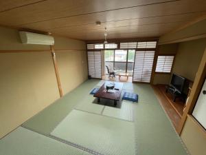 a living room with a table and a tv at Hotel Isodokei in Shirahama