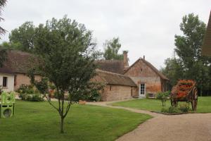 ein Haus mit einer Pferdekutsche in einem Hof in der Unterkunft Gîte des Belles Fontaines in Neung-sur-Beuvron