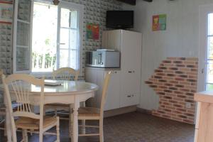 eine Küche mit einem Tisch und Stühlen sowie einem Kühlschrank in der Unterkunft Gîte des Belles Fontaines in Neung-sur-Beuvron