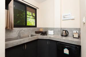 uma cozinha com um lavatório e uma janela em Koh Tao Heights Exclusive Apartments em Ko Tao