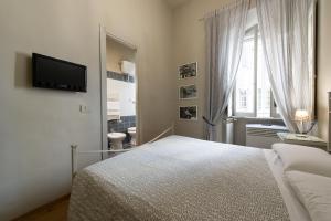 a white bedroom with a bed and a television at Residenza Ottaviani Roma in Rome
