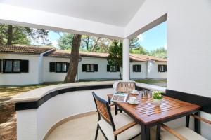 a patio with a table and chairs next to a pool at Apartments Galijot Plava Laguna in Poreč