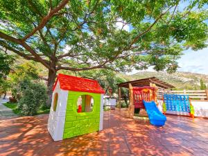 a group of playhouses sitting on a patio under a tree at Eco Hotel Montemerlo in Fetovaia
