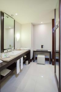 a bathroom with two sinks and a mirror at NH Collection Guadalajara Providencia in Guadalajara