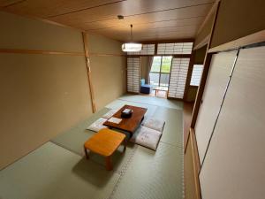Habitación con 2 mesas y bancos en una habitación en Hotel Isodokei, en Shirahama