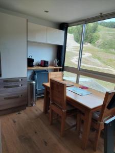 une cuisine avec une table et des chaises dans une pièce dans l'établissement Le grand cerf le Pelvou, à Vars 6 autres photos