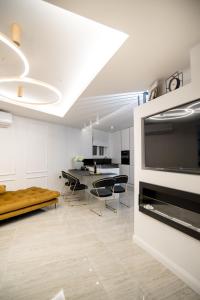 a white kitchen with chairs and a dining room at LUXURY apartment ROYAL IRIS in Njivice