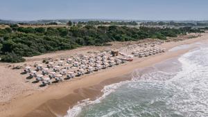 una vista aerea su una spiaggia con ombrelloni e sull'oceano di Mangia's Selinunte Resort a Marinella di Selinunte