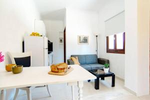La MAISON di Angelo STUDIO في Áyios Kírikos: غرفة معيشة مع طاولة وأريكة