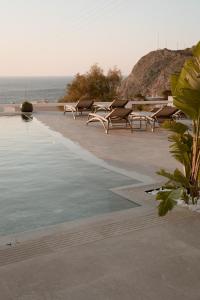 a row of chairs sitting next to a swimming pool at Mon Signor in Kamari