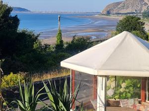 a white tent with a view of the beach at Stunning Sea view Immaculate 4-Bed family House in Penmaen-mawr