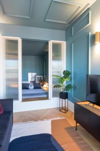 un soggiorno con pareti blu e un grande specchio di HM - Infante Riverside Apartment N a Porto