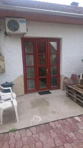 a white house with a red door and a patio at Majorka in Balatonfenyves