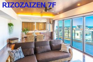 宜野灣的住宿－リゾザイゼンホテル，带沙发的客厅和阳台
