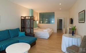 - un salon avec un canapé et un lit dans l'établissement Posada torre del milano, à Comillas