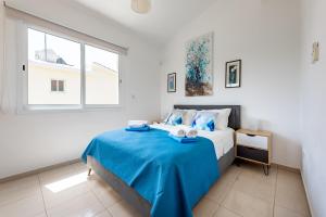 a bedroom with a large bed with a blue blanket at Villa Alysia by Ezoria Villas in Coral Bay