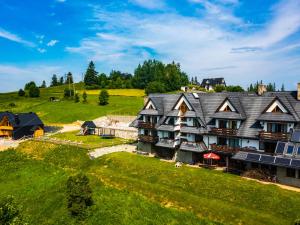 an aerial view of a large house on a green hill at Willa Majerczyk in Poronin
