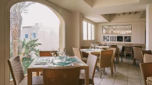 a restaurant with tables and chairs and a large window at Mangia's Favignana Resort in Favignana