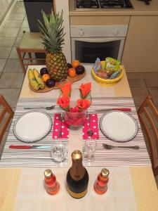 une table avec des assiettes, un ananas et un vase de fleurs dans l'établissement Casa Vacanze In Love, à Marina di Montemarciano