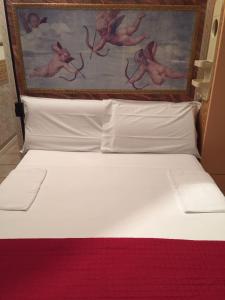 a bed in a hotel room with a painting above it at Casa Vacanze In Love in Marina di Montemarciano