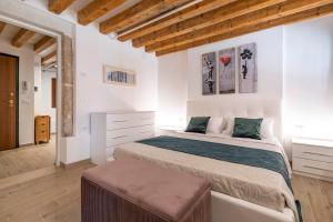 una camera con un grande letto in una stanza con soffitti in legno di Palazzo Preziosa - Rialto a Venezia