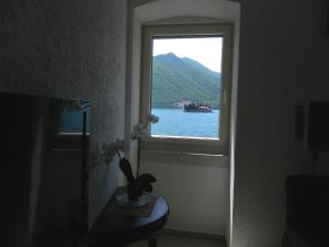 a window in a room with a view of the water at Apartments David in Perast