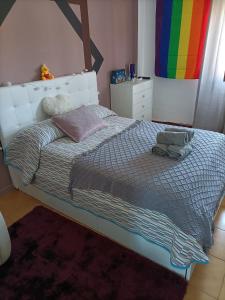 1 dormitorio con 1 cama con bandera de arco iris en la pared en Hospedaje La Ijana en Bádames