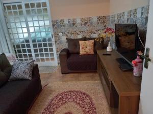 ein Wohnzimmer mit Sofa und Tisch in der Unterkunft Recanto Flor de lis in Gonçalves