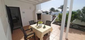 einen Tisch und Stühle auf einer Terrasse mit Balkon in der Unterkunft Casa Lento in Tías