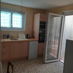 una cocina con fregadero y una puerta que da a una cocina en les mésanges en Chaffaut-Lagremuse