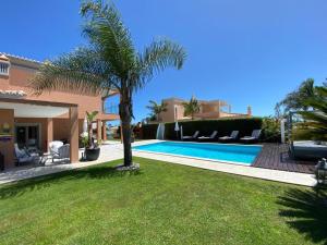 a villa with a palm tree and a swimming pool at Casa Corais in Guia