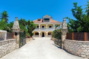 una grande casa con recinzione e vialetto di La Maison di Angelo 2 Apartment Zakynthos Island ad Áyios Kírikos