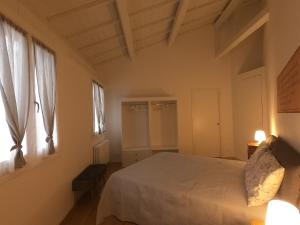 - une chambre avec un lit blanc et 2 fenêtres dans l'établissement Al Vecchio Essicatoio, à Bassano del Grappa